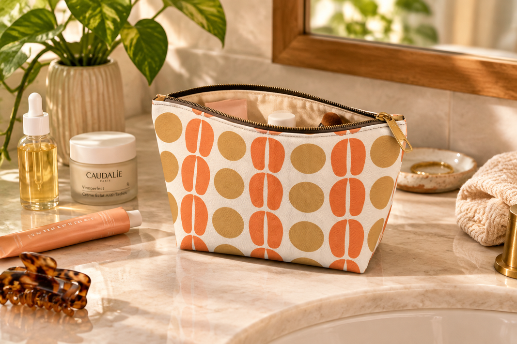 Mid-Century Orange Dot Accessory Pouch on counter with makeup