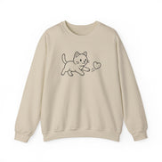 A beige crewneck sweatshirt featuring a simple black line art graphic of a kitten playing with a heart on the chest, displayed against a clean white background.