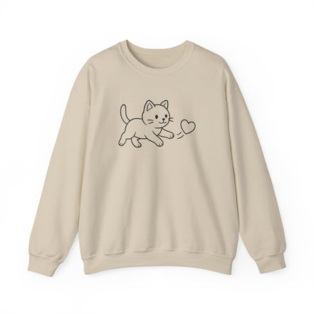 A beige crewneck sweatshirt featuring a simple black line art graphic of a kitten playing with a heart on the chest, displayed against a clean white background.