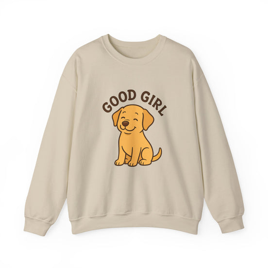 A beige crewneck sweatshirt featuring a cartoon graphic of a golden retriever puppy sitting underneath the text 'GOOD GIRL' in brown.