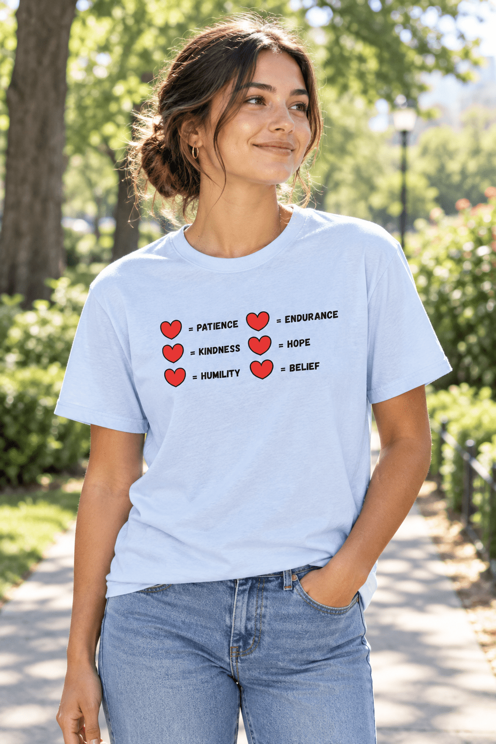 A  tee worn by young woman in jeans outside tee has a two rows of hearts with equal signs. in a row next to the = signs are the words 