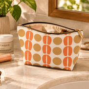 Mid-Century Orange Dot Accessory Pouch on counter with makeup